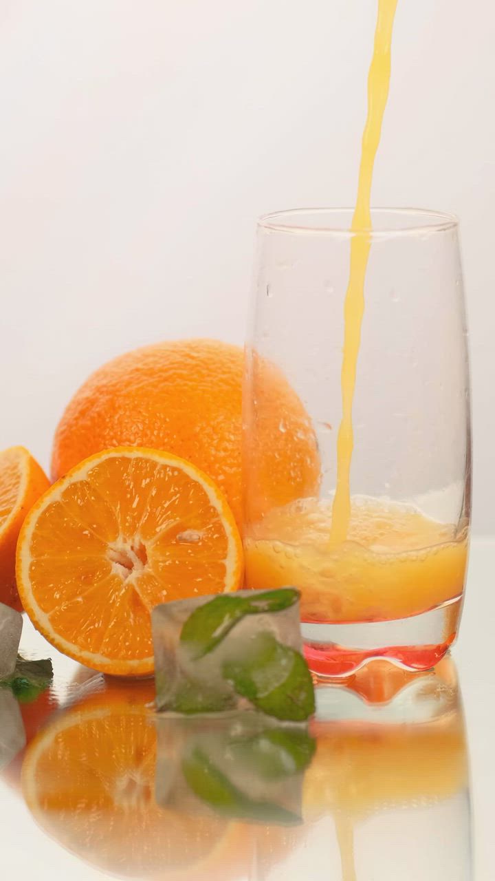 在玻璃杯中供应果汁，白色背景上有一些橙子视频模板素材完整版免费下载